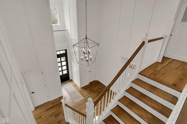 entrance foyer featuring wood finished floors and an inviting chandelier