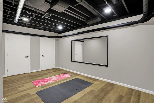 exercise room with baseboards and wood finished floors