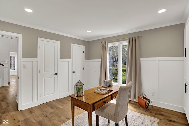 home office with a decorative wall, crown molding, a wainscoted wall, and light wood finished floors