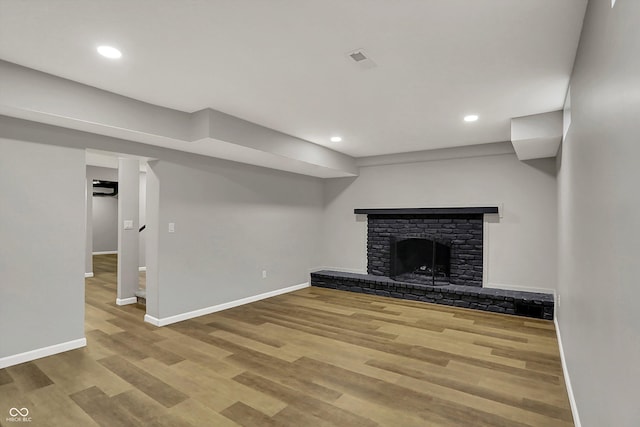 unfurnished living room featuring baseboards, wood finished floors, and a fireplace