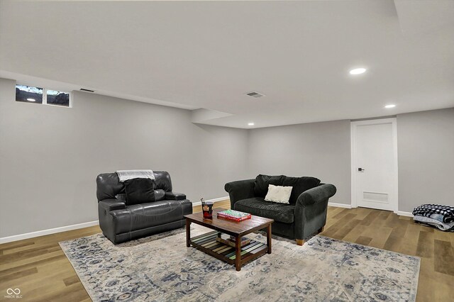 living area featuring baseboards, wood finished floors, visible vents, and recessed lighting