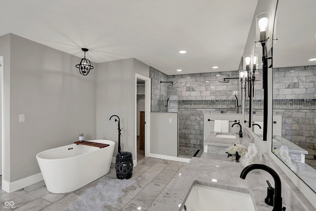 bathroom with a freestanding bath, marble finish floor, a walk in shower, and a sink