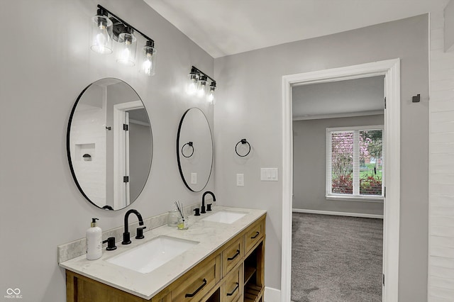 bathroom with double vanity, baseboards, and a sink