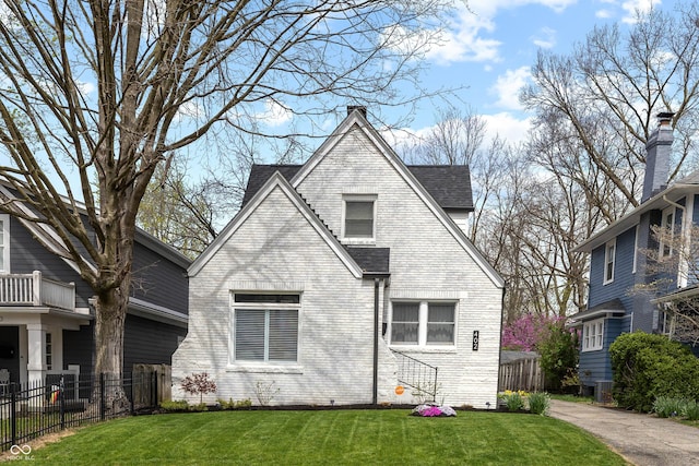 back of house with fence, a lawn, brick siding, and roof with shingles