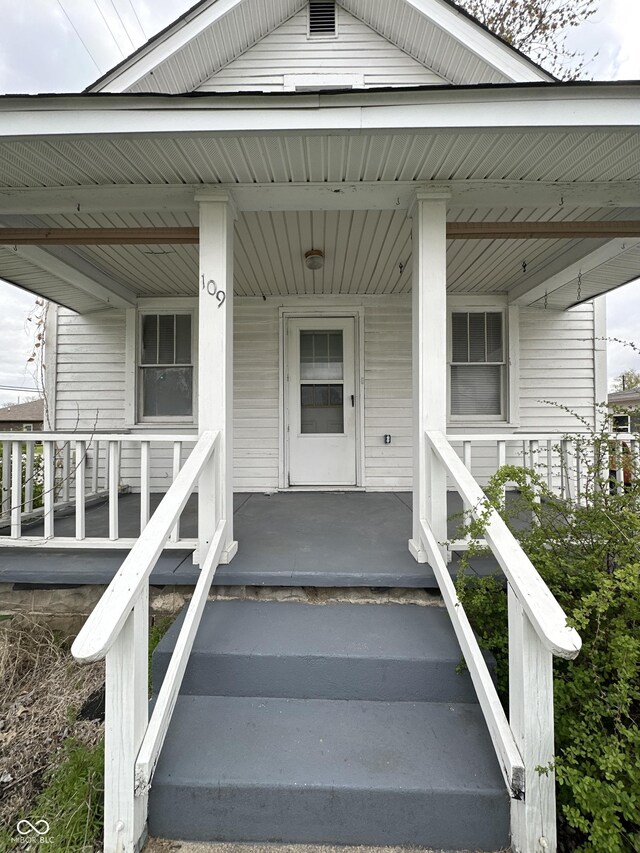 view of exterior entry featuring covered porch
