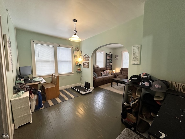 home office with wood-type flooring, baseboards, and arched walkways