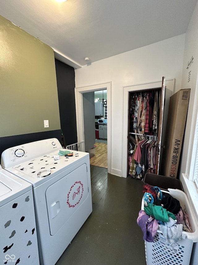 clothes washing area with washer and dryer, laundry area, and baseboards