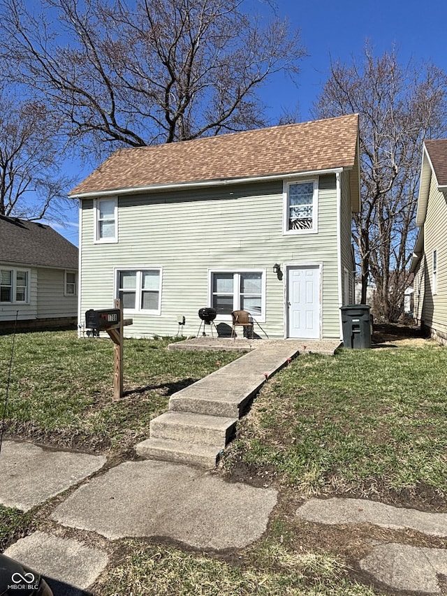 view of front of property with roof with shingles and a front lawn