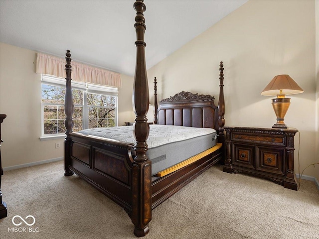 carpeted bedroom with baseboards and vaulted ceiling