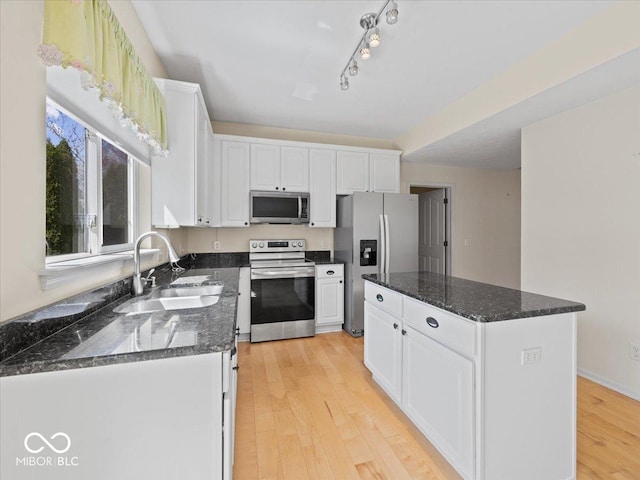 kitchen with white cabinetry, light wood-style floors, appliances with stainless steel finishes, and a sink