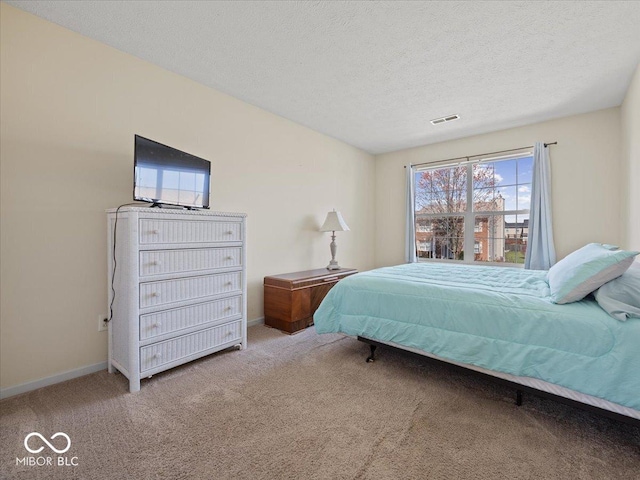 bedroom featuring carpet, a textured ceiling, visible vents, and baseboards