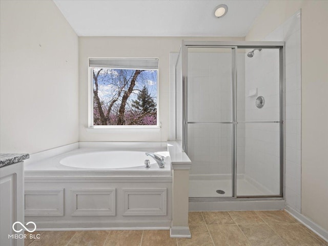 bathroom featuring a garden tub, a shower stall, and tile patterned floors