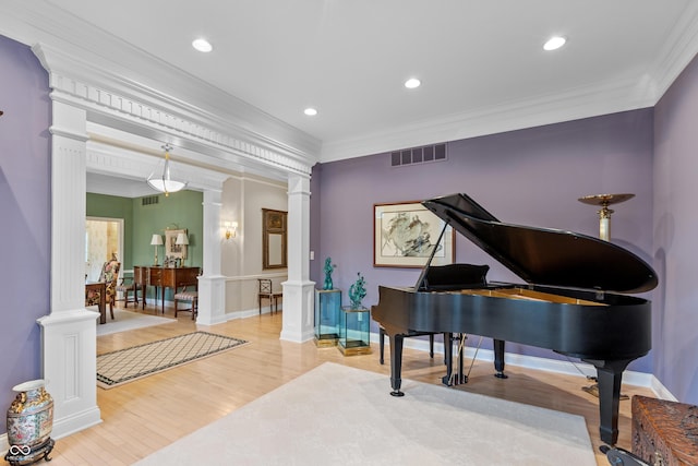 living area featuring ornamental molding, decorative columns, and visible vents