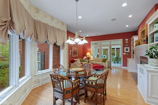 dining room with a fireplace, baseboards, light wood finished floors, a chandelier, and recessed lighting
