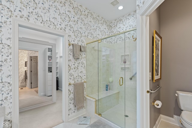 bathroom featuring toilet, wallpapered walls, visible vents, and a stall shower