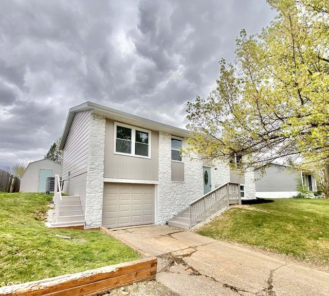 110 Renee Dr, Ellettsville, IN 47429 - view of front of house with stone siding, driveway, a garage, and a front lawn