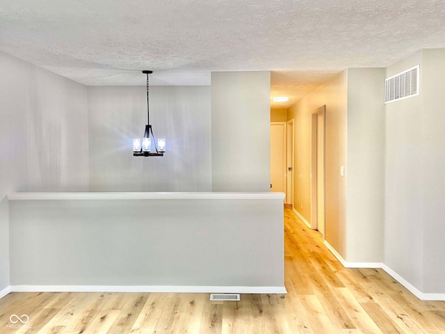 110 Renee Dr, Ellettsville, IN 47429 - hall featuring a textured ceiling, light wood finished floors, and a chandelier