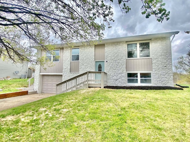 110 Renee Dr, Ellettsville, IN 47429 - bi-level home with stone siding, driveway, a garage, and a front yard