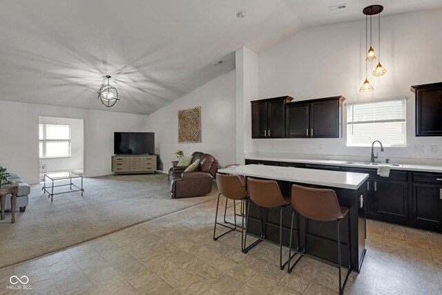 4323 Stubbington Ln, Indianapolis, IN 46239 - kitchen featuring lofted ceiling, a sink, a center island, light countertops, and a kitchen bar