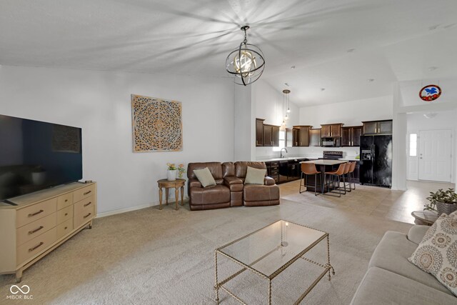 4323 Stubbington Ln, Indianapolis, IN 46239 - living room featuring high vaulted ceiling, light colored carpet, a chandelier, and baseboards
