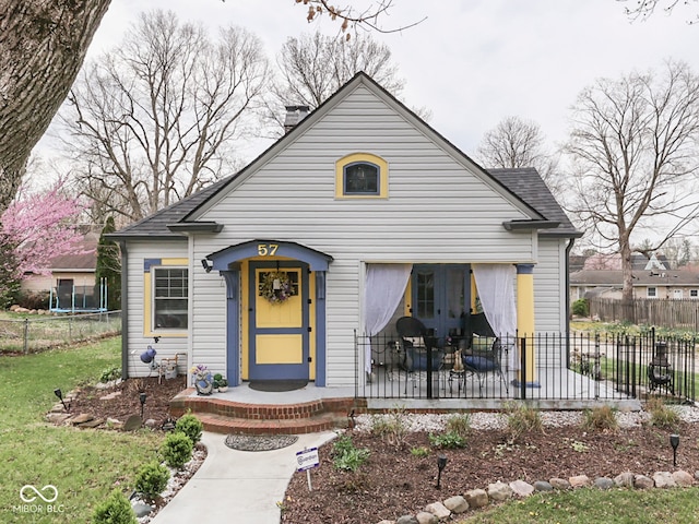 57 Worman St, Indianapolis, IN 46227 - view of front of home with fence, a shingled roof, a front lawn, and french doors