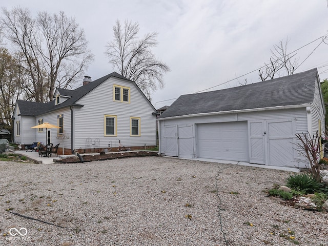 57 Worman St, Indianapolis, IN 46227 - exterior space with a chimney, an outbuilding, a shingled roof, and a garage