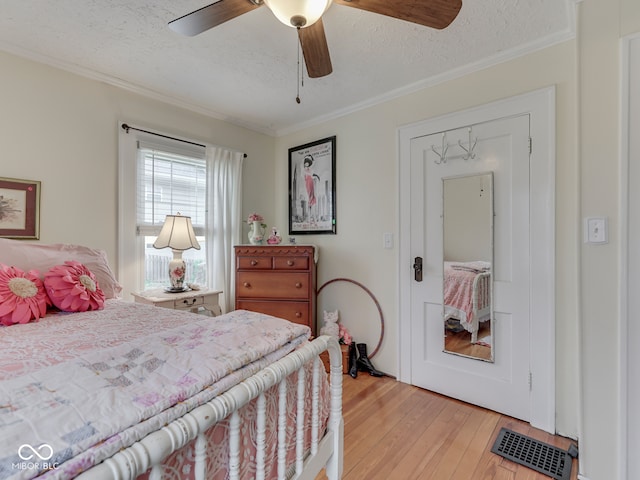 57 Worman St, Indianapolis, IN 46227 - bedroom featuring a textured ceiling, visible vents, light wood-style floors, a ceiling fan, and crown molding