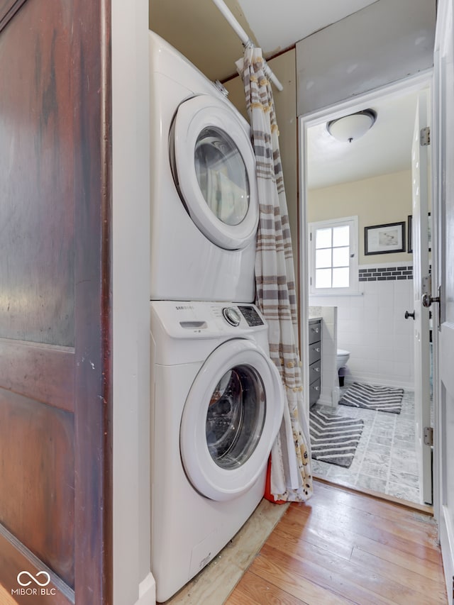 57 Worman St, Indianapolis, IN 46227 - clothes washing area with wood finished floors, stacked washer and dryer, and laundry area