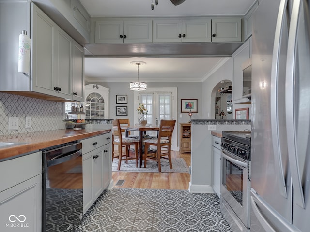 57 Worman St, Indianapolis, IN 46227 - kitchen with decorative light fixtures, light wood-type flooring, crown molding, tasteful backsplash, and appliances with stainless steel finishes