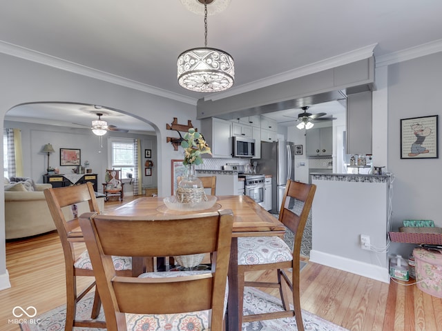 57 Worman St, Indianapolis, IN 46227 - dining area featuring arched walkways, light wood-style floors, crown molding, and ceiling fan