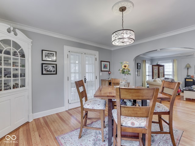 57 Worman St, Indianapolis, IN 46227 - dining space featuring light wood finished floors, an inviting chandelier, arched walkways, and ornamental molding
