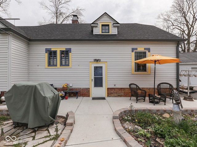 57 Worman St, Indianapolis, IN 46227 - back of property featuring a patio area, a shingled roof, and a chimney