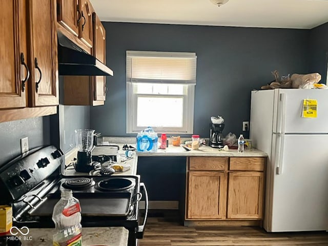 801 N Denny St, Indianapolis, IN 46201 - kitchen with brown cabinets, range with electric cooktop, light countertops, wood finished floors, and freestanding refrigerator