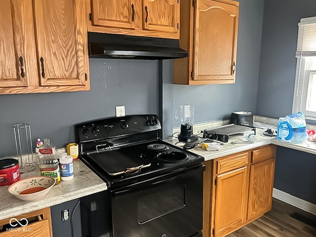 801 N Denny St, Indianapolis, IN 46201 - kitchen with light countertops, under cabinet range hood, dark wood-type flooring, and electric range
