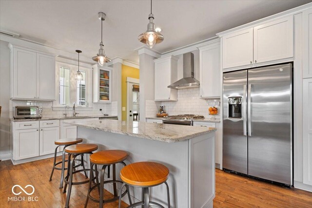7638 Beekman Ter, Zionsville, IN 46077 - kitchen with appliances with stainless steel finishes, wall chimney range hood, tasteful backsplash, white cabinetry, and ornamental molding