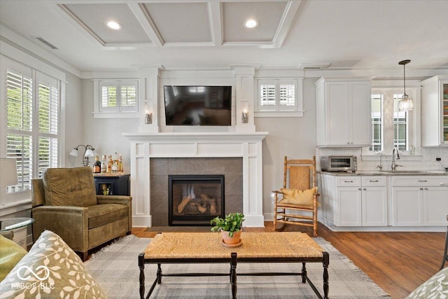 7638 Beekman Ter, Zionsville, IN 46077 - living area with light wood-style flooring, recessed lighting, a tile fireplace, and crown molding
