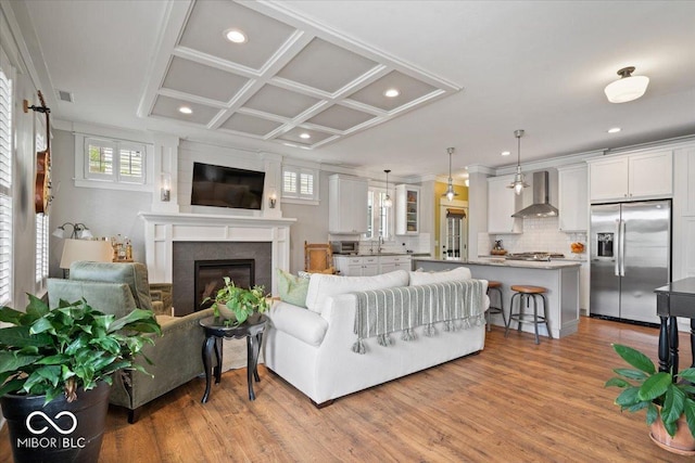 7638 Beekman Ter, Zionsville, IN 46077 - living room with recessed lighting, a glass covered fireplace, light wood-style floors, and coffered ceiling