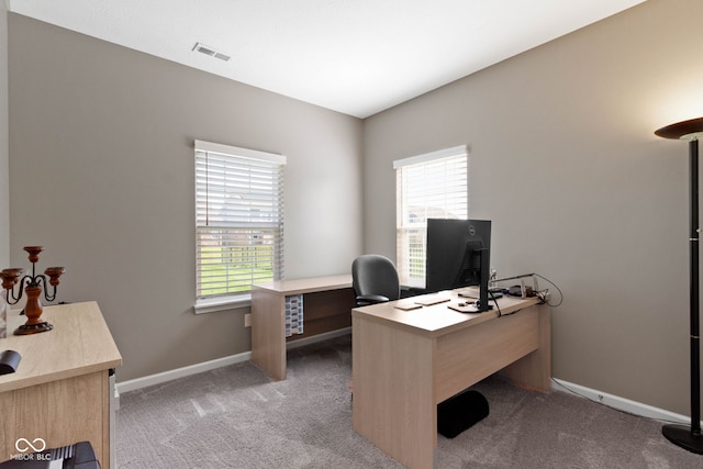 office space with baseboards, plenty of natural light, light carpet, and visible vents