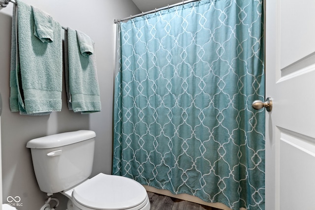 full bathroom featuring curtained shower, toilet, and wood finished floors