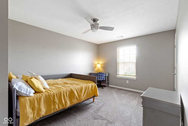 carpeted bedroom with baseboards, a ceiling fan, and visible vents