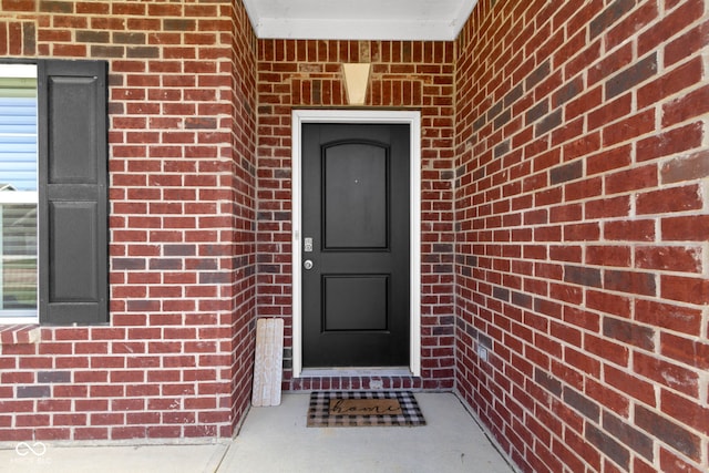 property entrance featuring brick siding