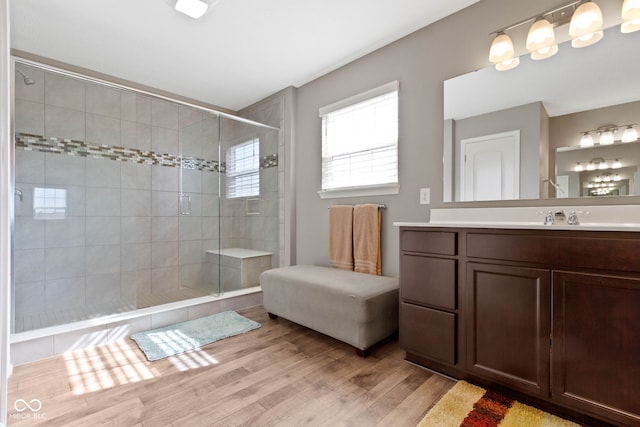 bathroom with a shower stall, wood finished floors, and vanity