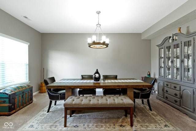 carpeted dining area featuring baseboards, an inviting chandelier, and visible vents