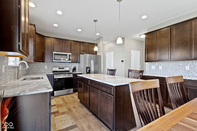 kitchen with a sink, backsplash, dark brown cabinets, and stainless steel appliances