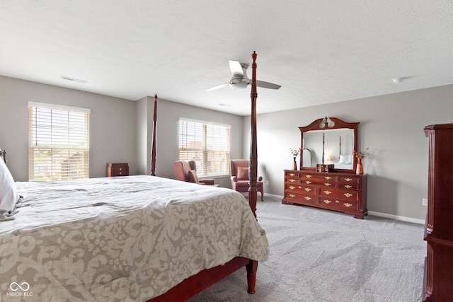 bedroom with baseboards, carpet flooring, a textured ceiling, and a ceiling fan