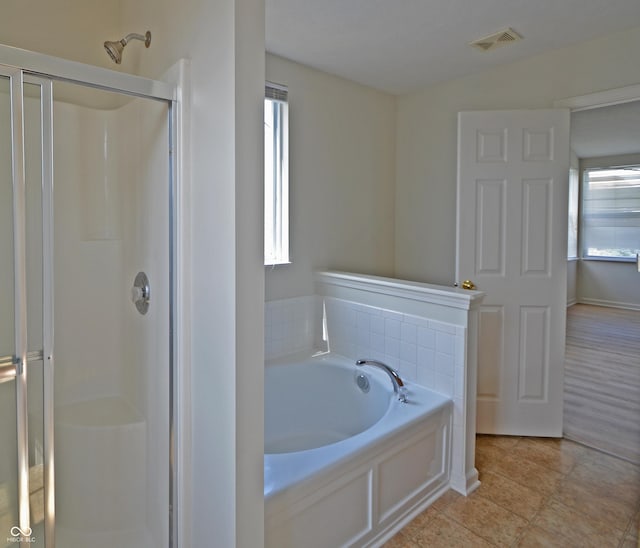 full bathroom with a bath, a shower stall, and visible vents