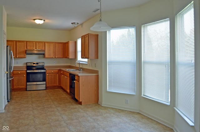 kitchen featuring a sink, stainless steel appliances, under cabinet range hood, light countertops, and hanging light fixtures