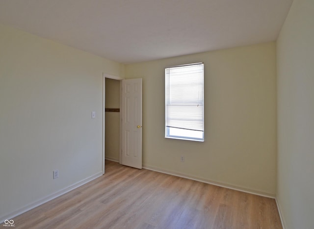 empty room with light wood-type flooring and baseboards
