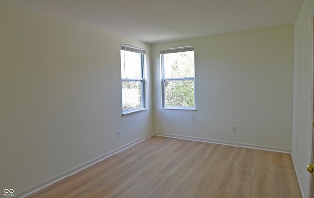 empty room featuring baseboards and light wood-style flooring