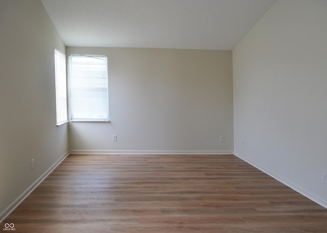 unfurnished room with wood finished floors and baseboards